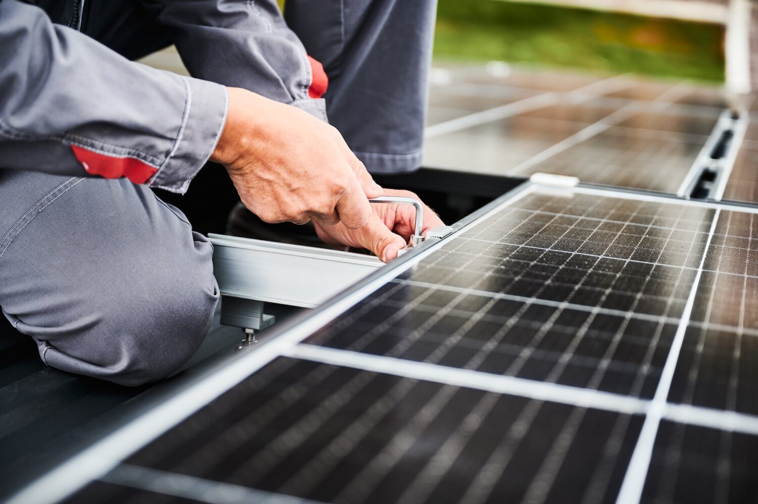 Man technician mounting photovoltaic solar panels on roof of house.